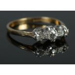 An 18ct Gold and Platinum three stone Diamond ring. Size: MÂ½. Total weight: 3.0g. Largest stone: