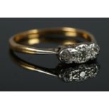 An 18ct Gold and Platinum illusion set three stone diamond ring. Size LÂ½. Total weight: 1.7g.