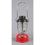 A red based Tilley light. 33cm high (excluding handle).