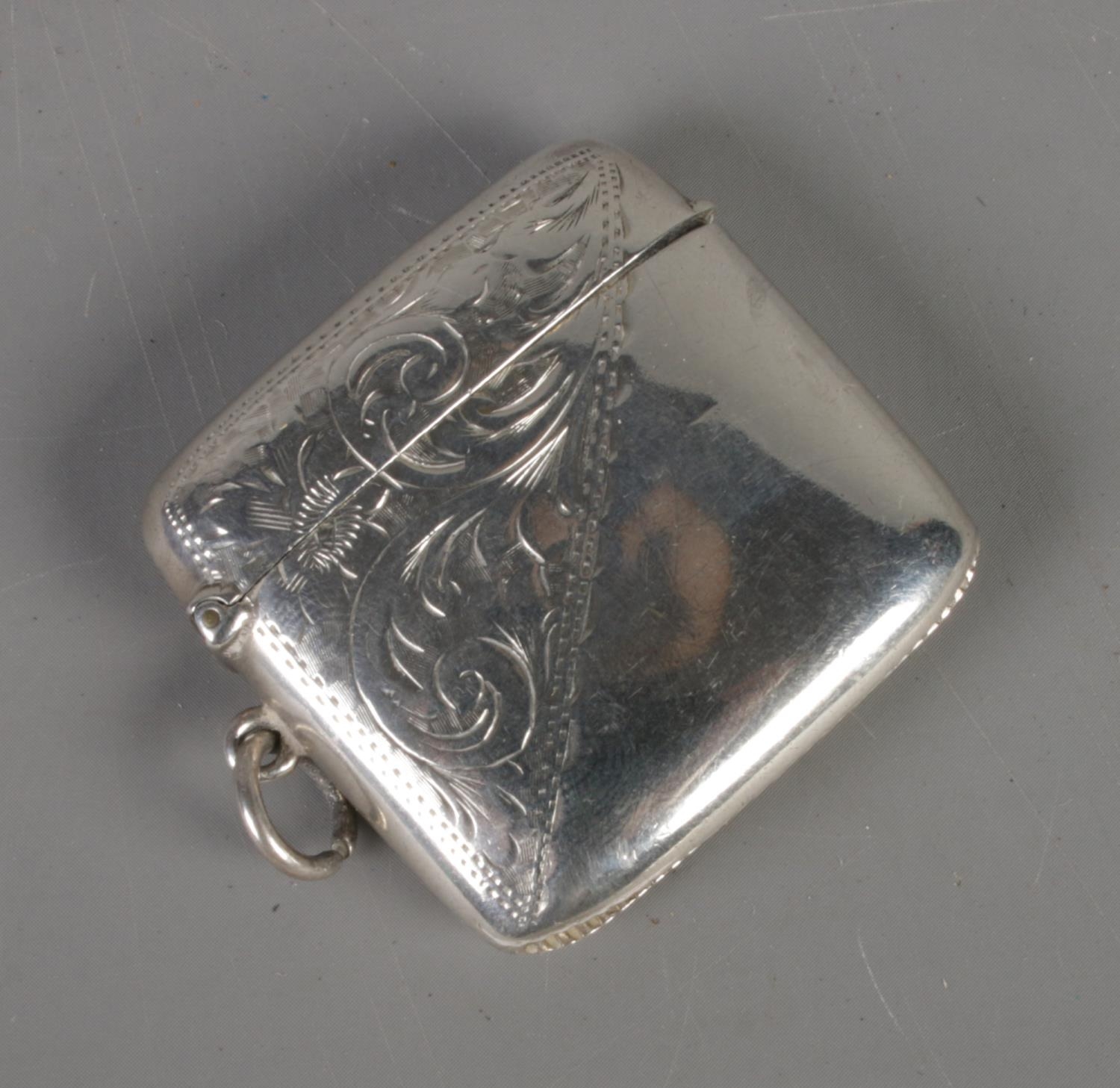 An early twentieth century silver vesta case, with corner scrolled decoration and gilt lining.