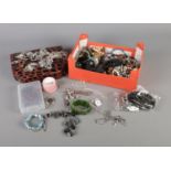 A box of assorted costume jewellery to include beaded necklaces, bracelets, white metal brooches,