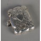 A George V silver vesta case, with scrolled decoration and central shield. Assayed for Birmingham,