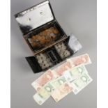 A metal cash box with key and contents of coins. Including one shillings, six pence, bank notes,