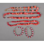 A quantity of coral necklaces along with two coral and opaline bracelets.