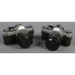 Two Canon AE-1 SLR cameras. Both with Canon 50mm 1:1.8 lens. No scratches to lenses. Both appear