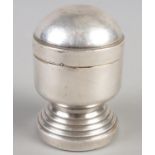 A white metal table lighter raised on circular stepped base. (8cm)