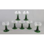 A set of seven French etched glass goblets, with green ribbed stems.