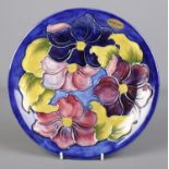 A Moorcroft dish decorated in the Clematis design. Diameter 26cm.