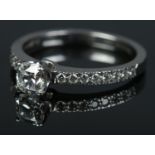 A Tiffany & Co Harmony platinum and diamond ring. The brilliant cut centre stone in claw setting