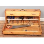A hinged pine tool case, with contents of tools. To include saws, mallet, drill bits, files etc.