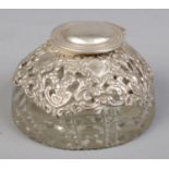 An Edwardian silver mounted glass ink well with hinged cover and hobnail cut base. Assayed