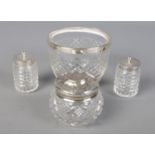 A cut glass silver rimmed bowl along with three silver lidded jars.