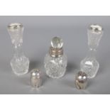 A pair of silver pepperettes along with a pair of cut glass silver rimmed vases and a silver