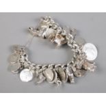 A silver and white metal charm bracelet, with charms including horse's head, boot, cart and three