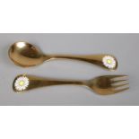 A silver gilt fork and spoon set by Georg Jensen, with matching enamel daisy decoration to each