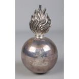 An Edwardian silver military grenade table lighter bearing the Brinkley family coat of arms to one