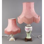 Two ceramic table lamps, one with floral detailing, the other with a decorative metal base. Complete