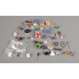 A collection of assorted badges and charms, including enamel examples.