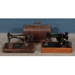 Two Singer sewing machines, comprising of dome topped case and 99k examples. Base damaged to cased