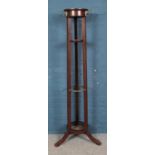 A large mahogany cylindrical coat and stick stand, with drip tray. 173cm tall. One leg missing.