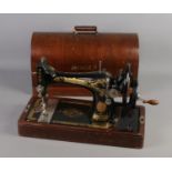 A dome top cased singer sewing machine, numbered Y7033976. Some enamel loss and age related wear.