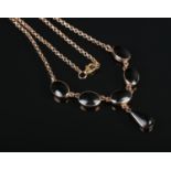 A 9ct Rose Gold necklace, set with 6 black stones, including central droplet. Central and droplet