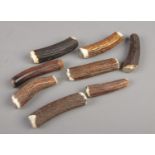 A collection of antler cutlery handles with white metal mounts.