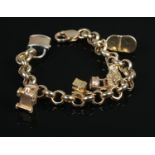 A 9ct Gold and Yellow metal charm bracelet, featuring charms including padlock, well and cart. Total