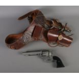 A 1974 model replica army 45 western revolver along with gun holster and spurs.