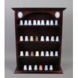 A Wedgwood thimble display stand containing thirty-one Wedgwood thimbles, many Christmas examples.