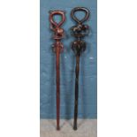 Two carved hardwood walking sticks depicting elephants, both with hooped handles. Darker example has