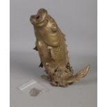 A bronze figure of a leaping carp. Portion of tail is missing with some damage to body and water