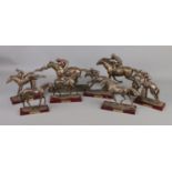 A collection of bronzed composite horse racing figures and riders. Some with damage.