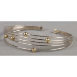 A two colour 9ct Gold bangle, in stranded and beaded design. Total weight: 7.6g