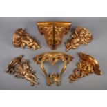 A collection of ornate gilt feature pieces, including wall shelves featuring cherubs.