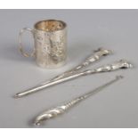 A silver christening cup along with a pair of silver handled glove stretchers and button hook. Cup