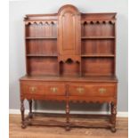 A carved oak dresser with domed top and turned supports. Cupboard will not stay closed.