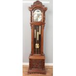 A modern carved longcase clock featuring roman numeral face and triple weights. Approx. height 206.