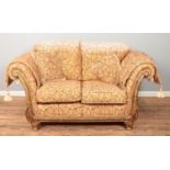 A Barker & Stonehouse style two seater sofa with gilt and floral upholstery. Height 93cm, Width