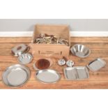 A box of metalwares. Includes stainless steel trays, flatware, etc.