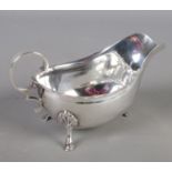 A silver sauceboat with scalloped edge. Raised on three stepped feet. Assayed London by Harrison