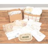 Two boxes of assorted linenware. To include tablecloths, doilies, napkins, handkerchiefs and curtain