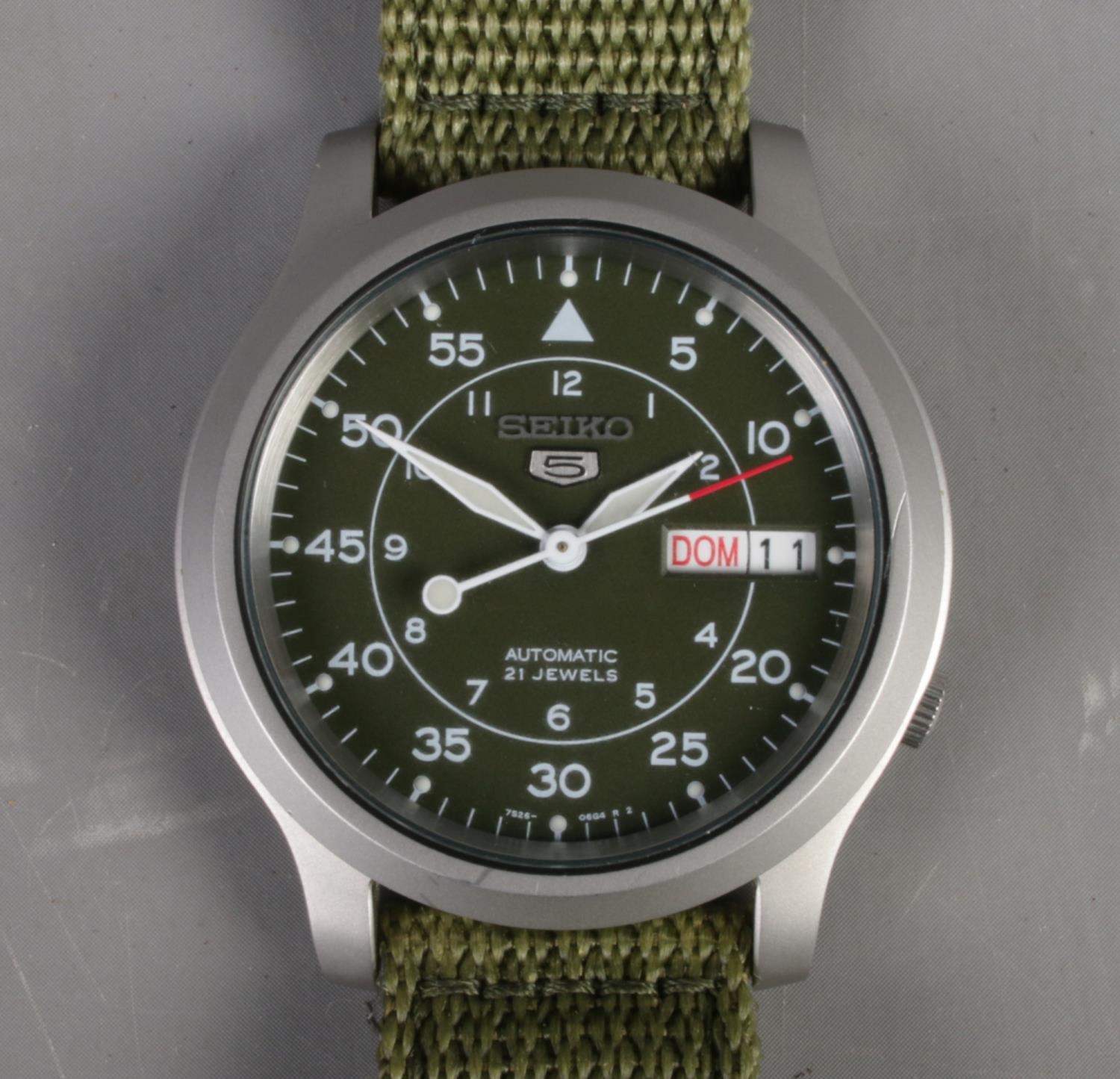 A Gentleman's Seiko 5 automatic wristwatch. With green dial and strap. Running.