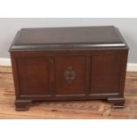 A paneled blanket box featuring central carved motif.