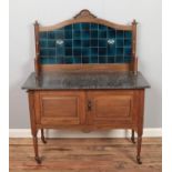 A marble topped wash stand featuring blue tiled back.