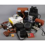A box of cameras and binoculars. Includes Nikon Coolpix3100 boxed camera, Panasonic Lumix TZ5