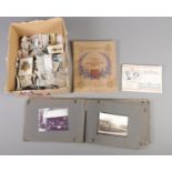 A box containing a vintage photograph/postcard album and assorted cigarette cards, loose and in