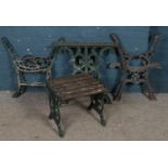 Two pairs of cast iron bench ends along with a pair of cast iron table supports and a small garden