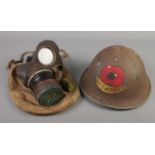 A WWII gas mask along with a tommy helmet with painted Lest We Forget rose.