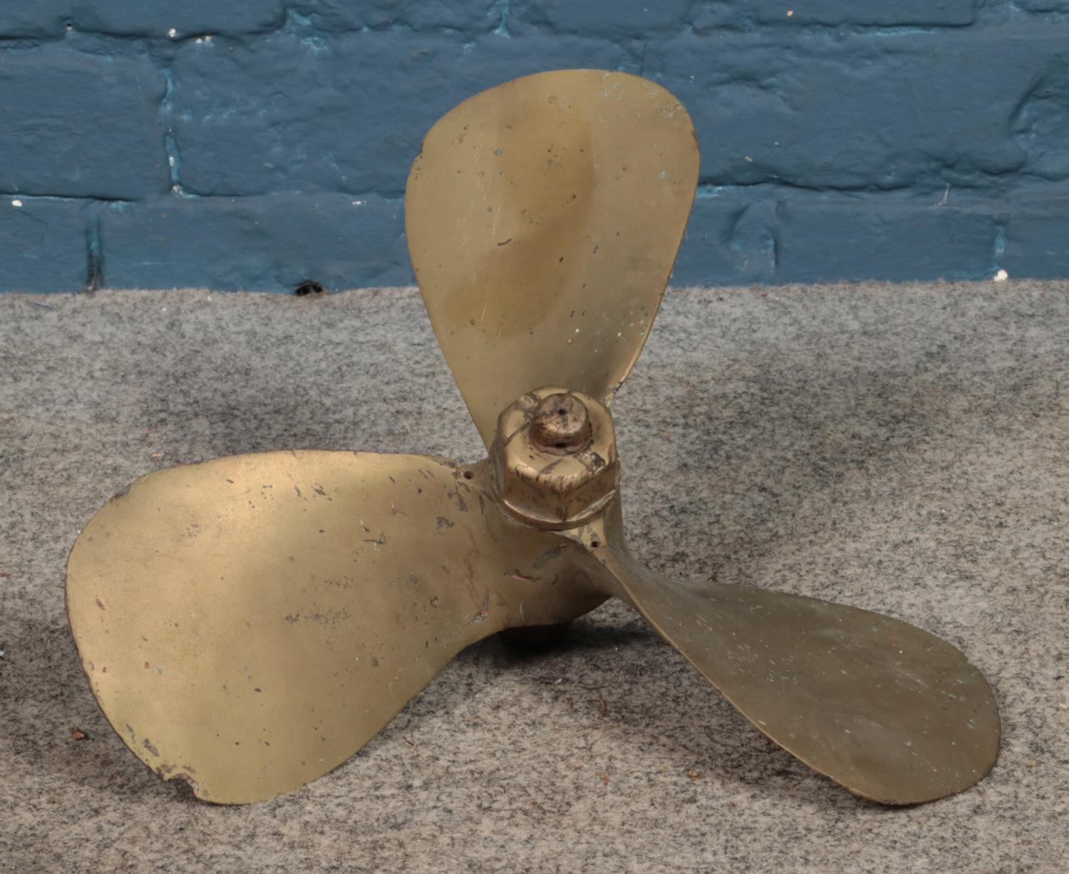 A brass three blade propellor stamped COBI.